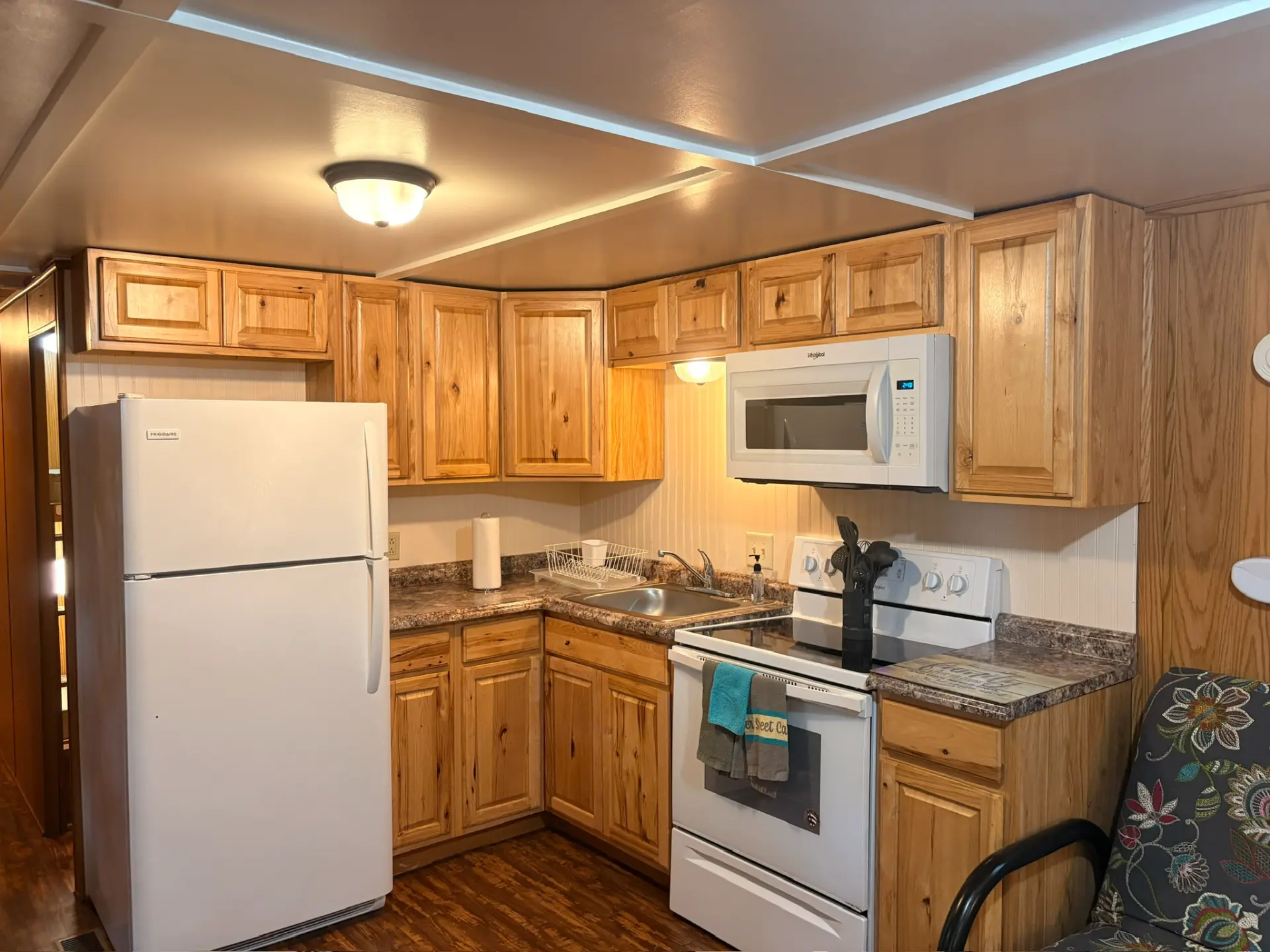 West Oak Lane 10 — Kitchen with knotty pine cabinets, granite-look counters, full-size refrigerator, range and over-the-range microwave