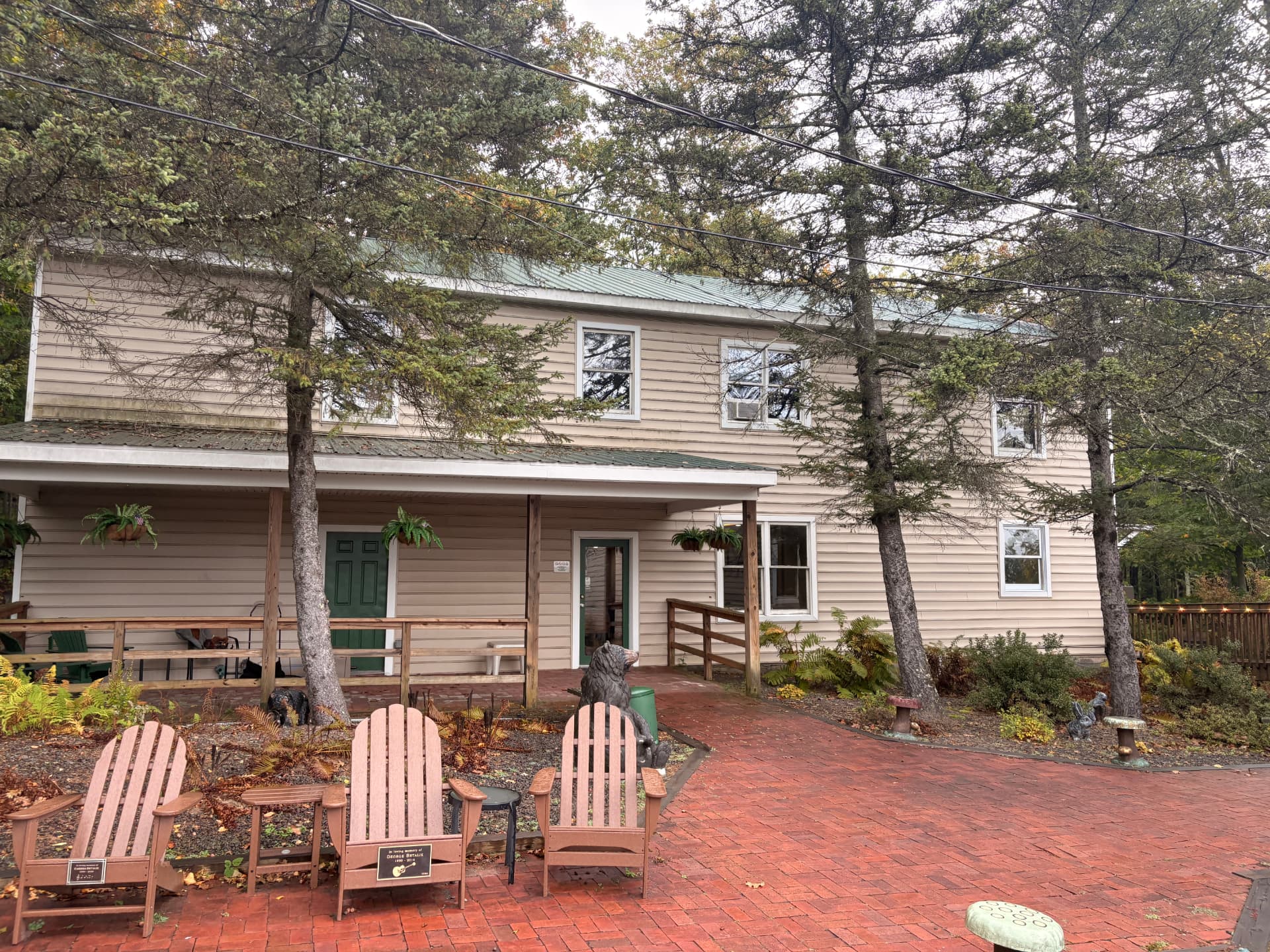 The two-story entertainment center building with a covered porch, brick courtyard and Adirondack chairs