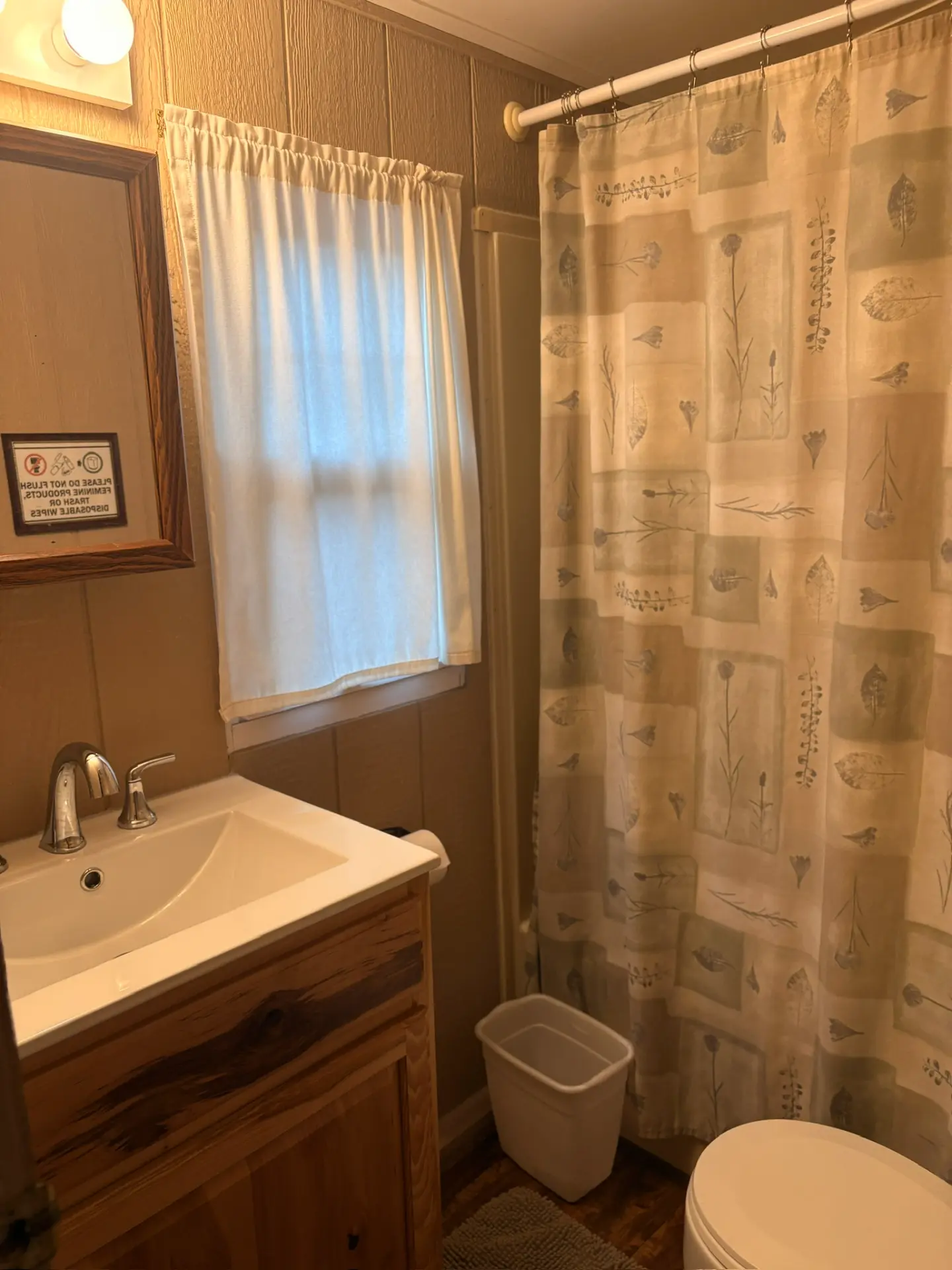 East Oak Lane 2 — Bathroom with vanity sink, mirror, toilet and shower with a leaf-print curtain