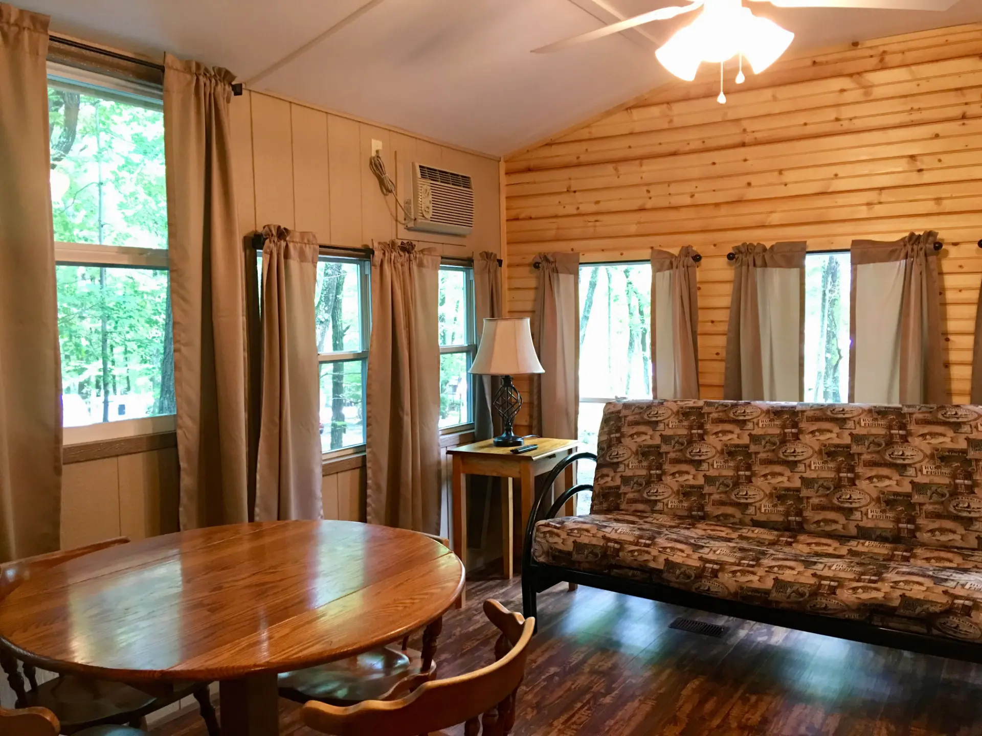 West Oak Lane 9 — Living and dining area with a vaulted knotty pine ceiling, oak table and futon