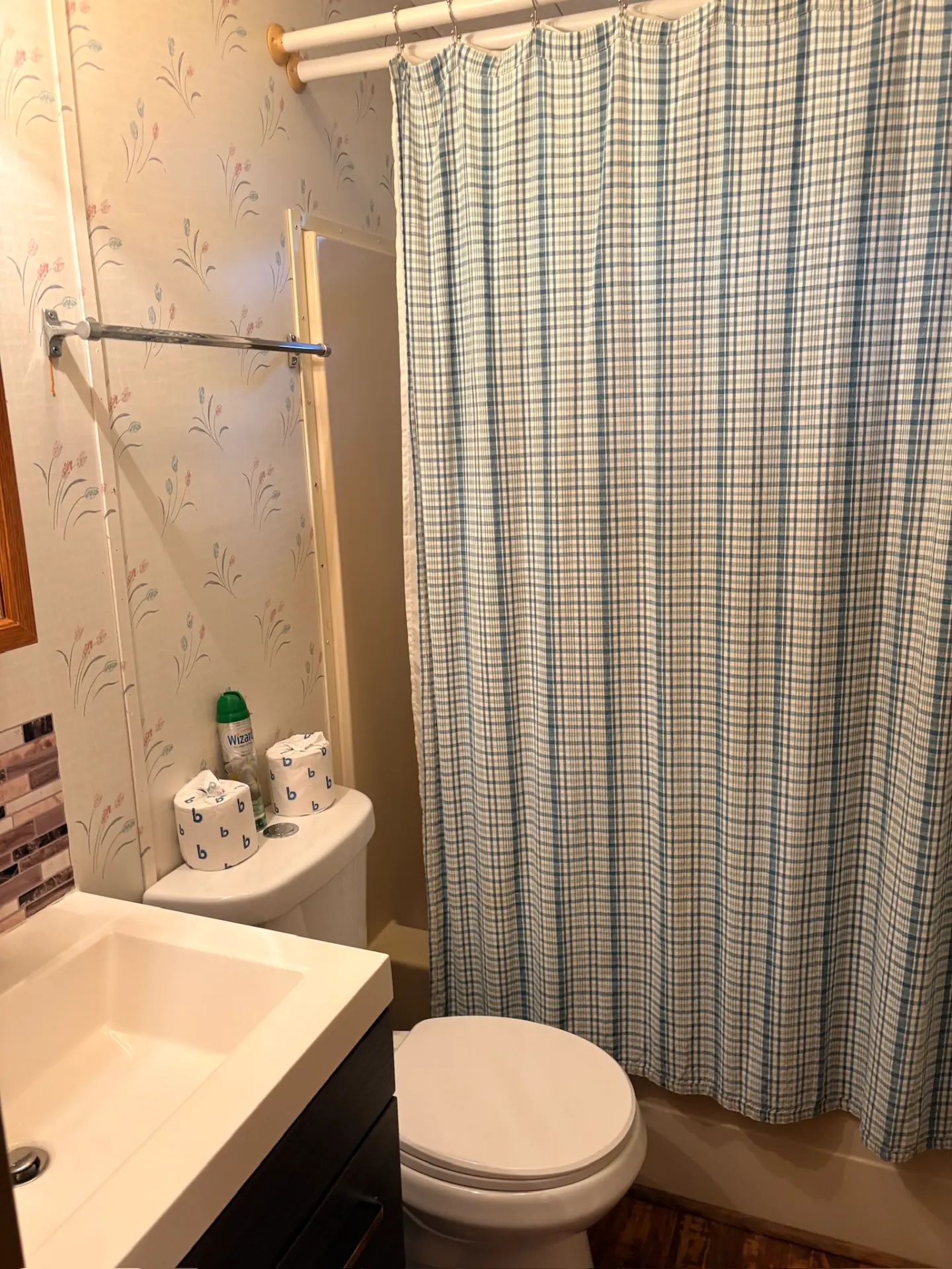 East Oak Lane 6 — Bathroom with a dark wood vanity, white sink, toilet and a blue plaid shower curtain