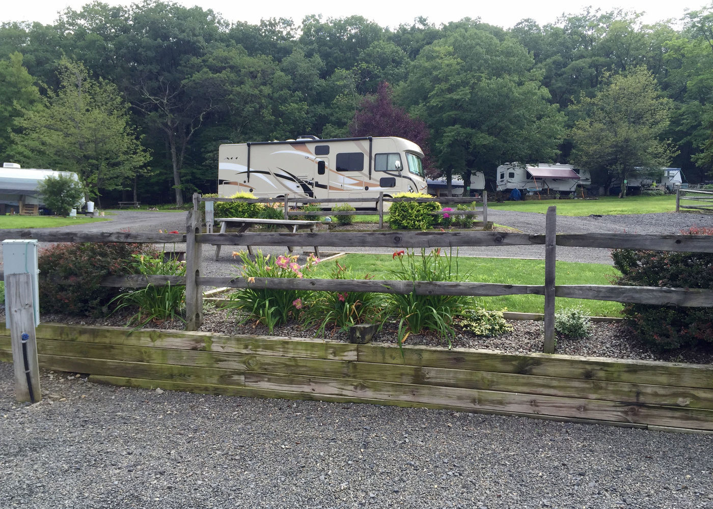 Motorhome settled on a gravel site with flowers