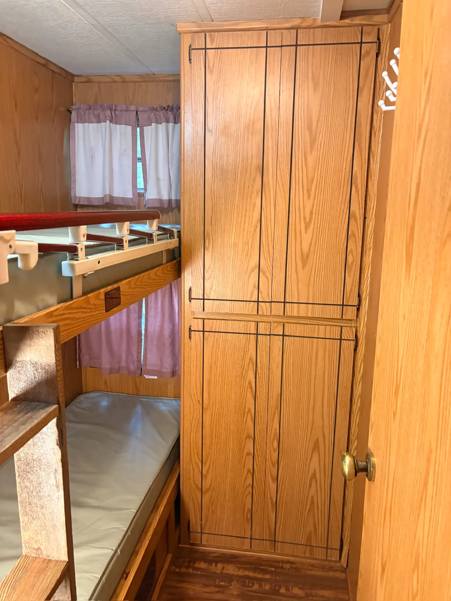 West Oak Lane 10 — Second bedroom with single bunk beds, curtained window and a tall oak wardrobe